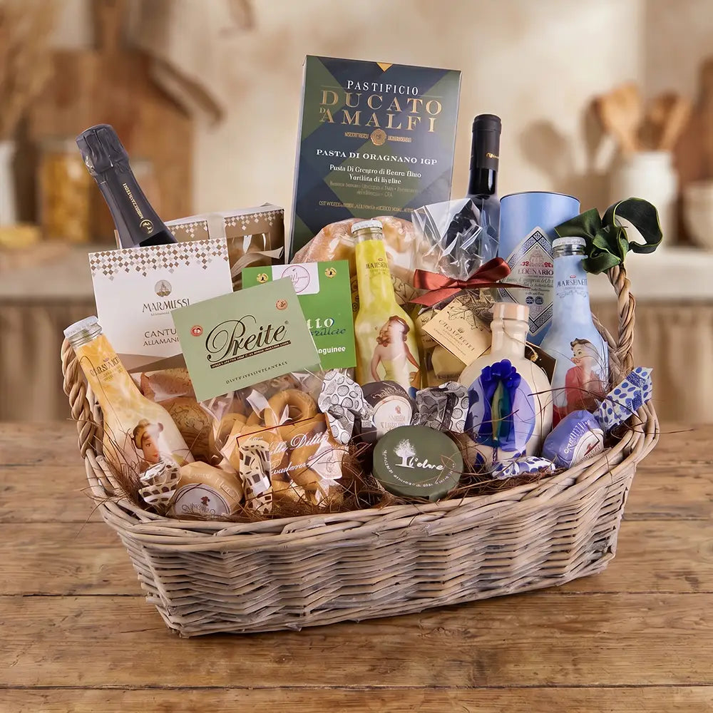 Italienischer Feinkost Geschenkkorb mit Pasta, Olivenöl, Wein, Süßwaren und mediterranen Delikatessen in einem geflochtenen Korb auf rustikalem Holztisch